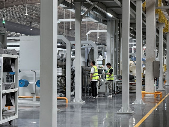 Workers operating tire-making machinery